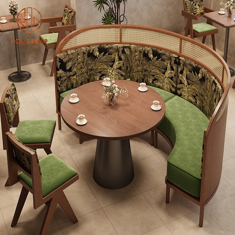 Curved Rattan-Back Booth Banquette with Botanical Upholstery, Round Wood Table & Matching Café Chairs